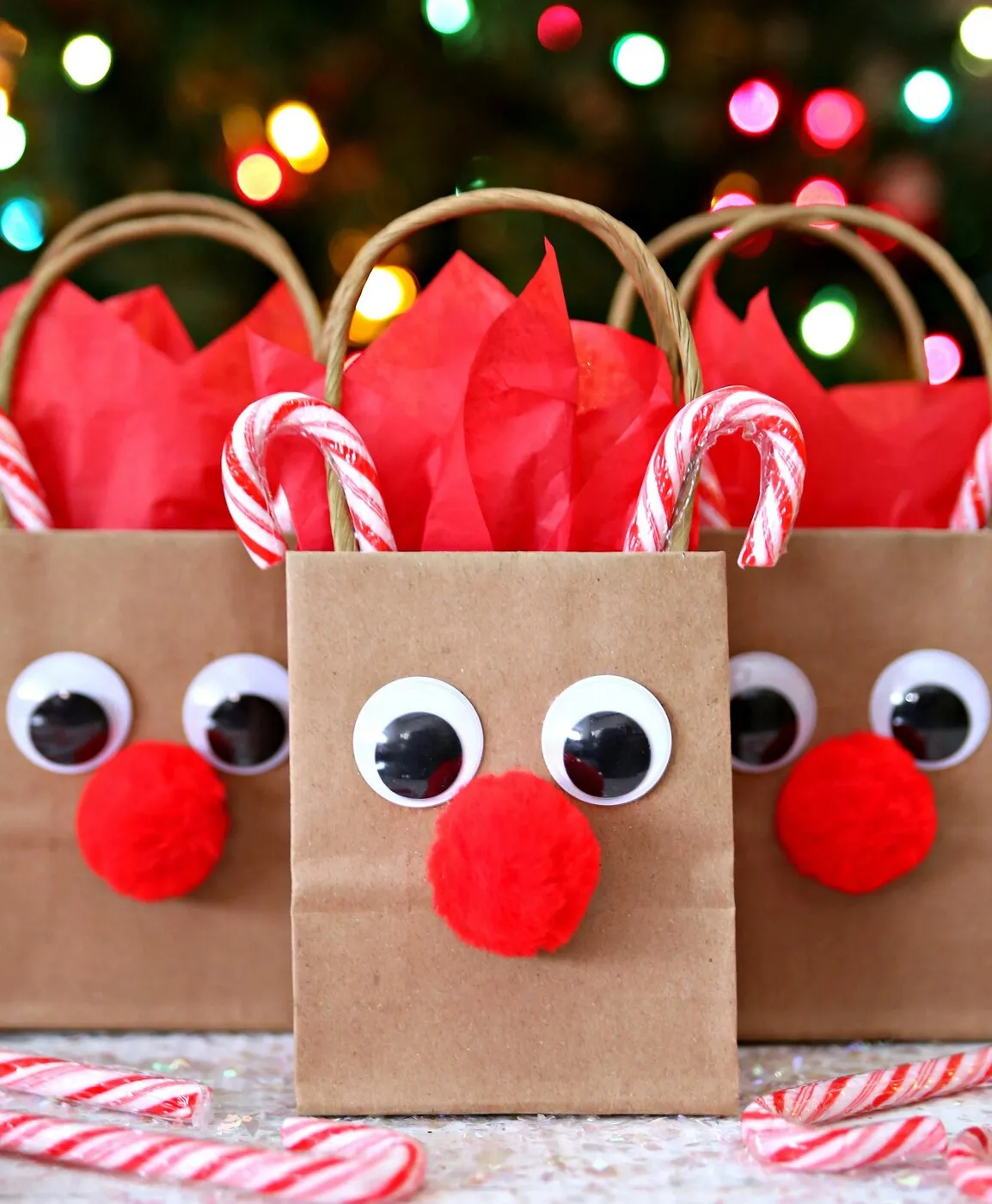 Reindeer-themed kraft gift bags with candy canes