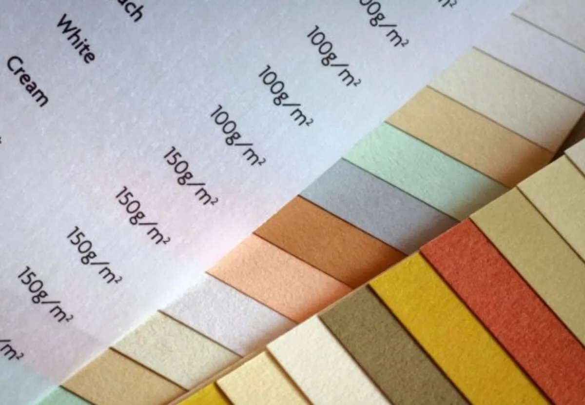Paper swatch strips in white and cream labelled with GSM weights