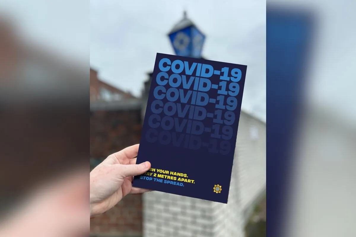 COVID-19 navy poster held outdoors for An Garda Siochana