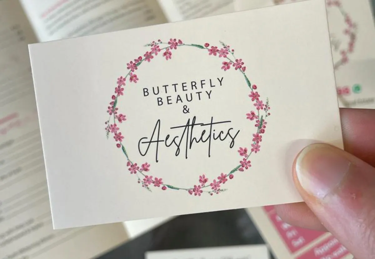 Hand holding a printed Butterfly Beauty business card