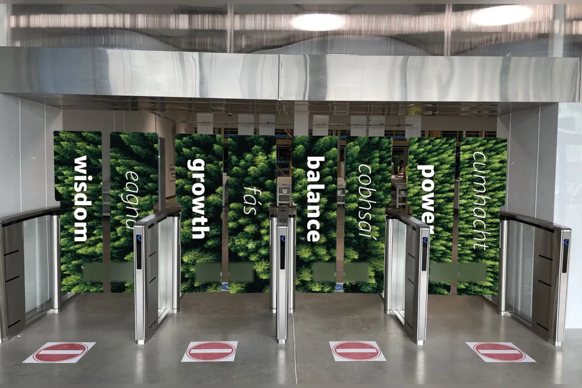 Fulfilment centre turnstiles with forest wall graphics and Irish and English wording