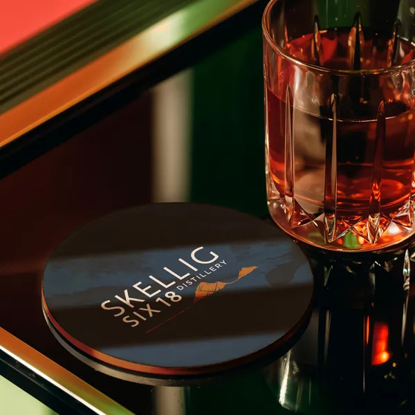 Skellig distillery branded beer mat under a glass of whiskey