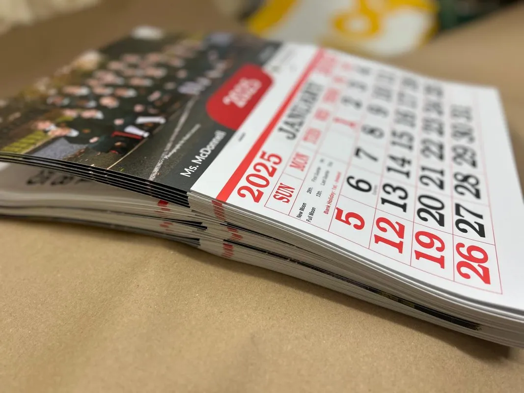 2025 wall calendars with month grids stacked on a table - Print Ready