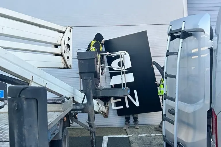 Print Ready team installing the Roca Tiles aluminium sign with a cherry picker