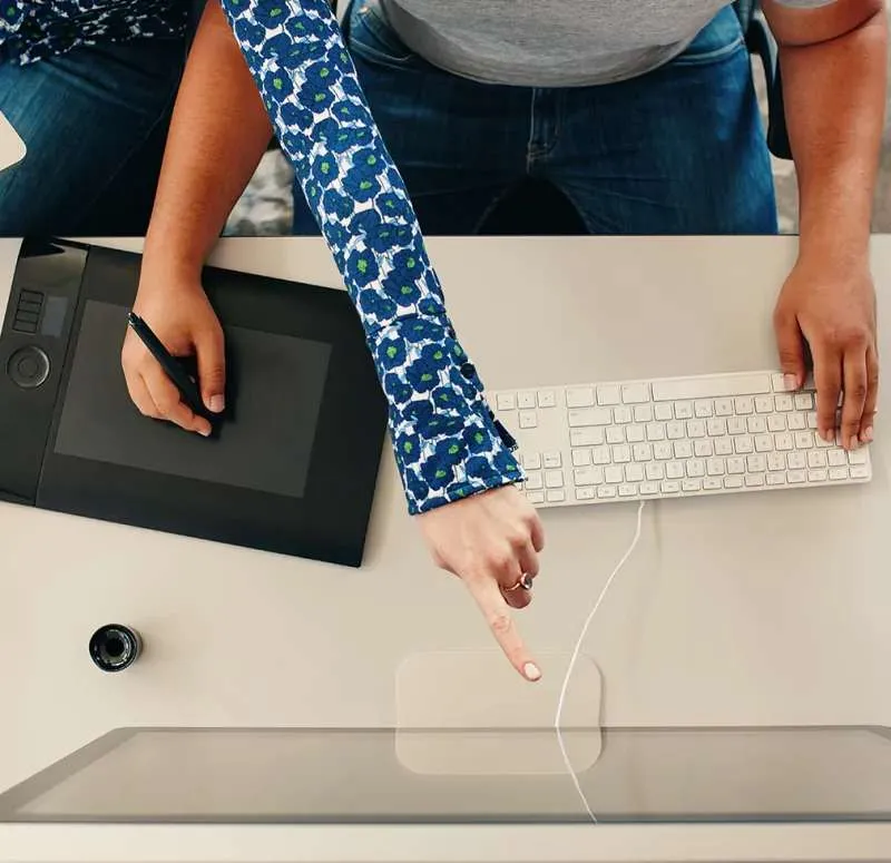 Designer working at desk with graphics tablet and computer