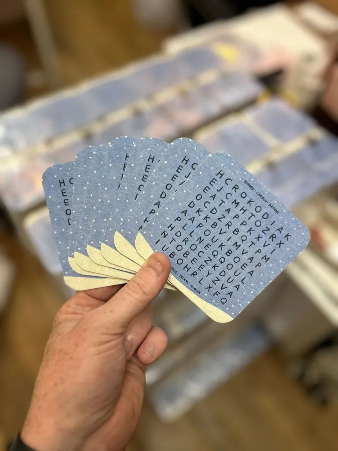 Fanned printed beermats held in hand