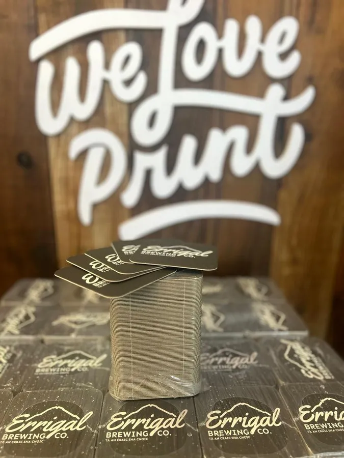 Printed beermats stacked in the Print Ready workshop