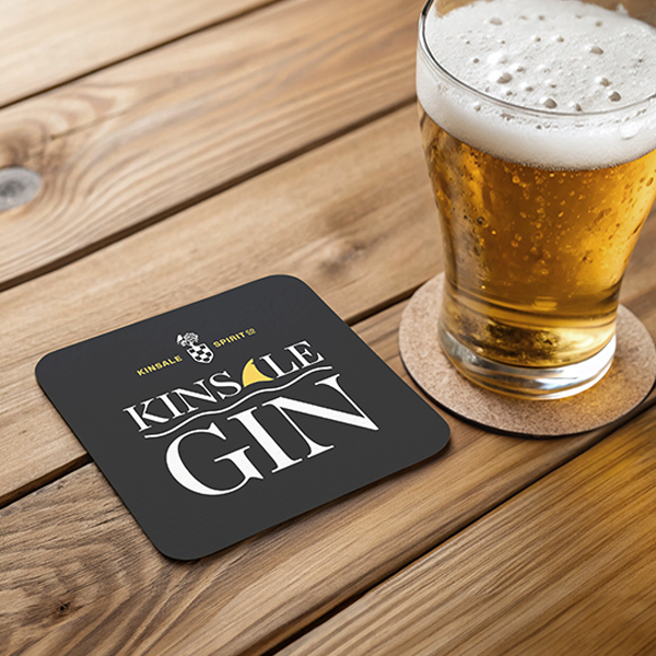 Custom printed square Kinsale Gin beermat beside a pint in an Irish pub