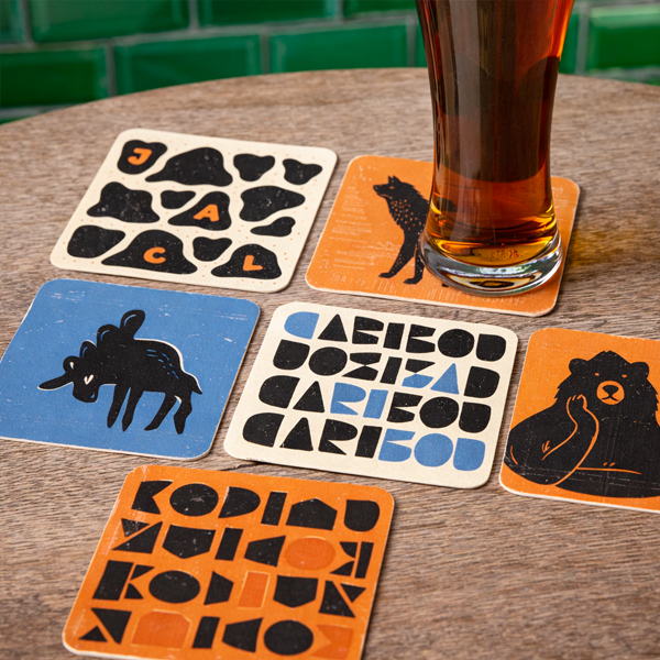 Set of colourful custom printed square beermats on a pub table